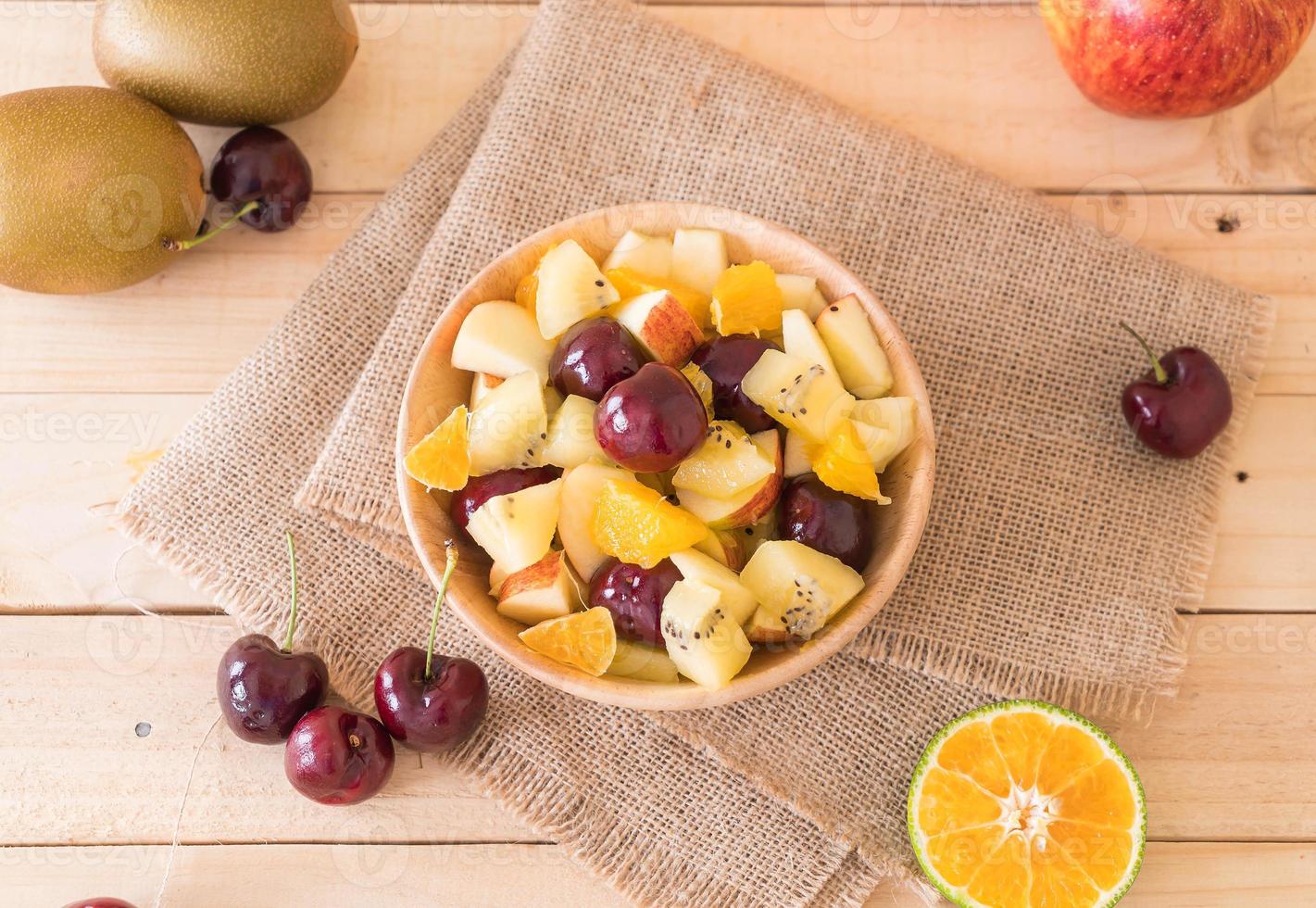 frutta mista a fette nel piatto di legno foto