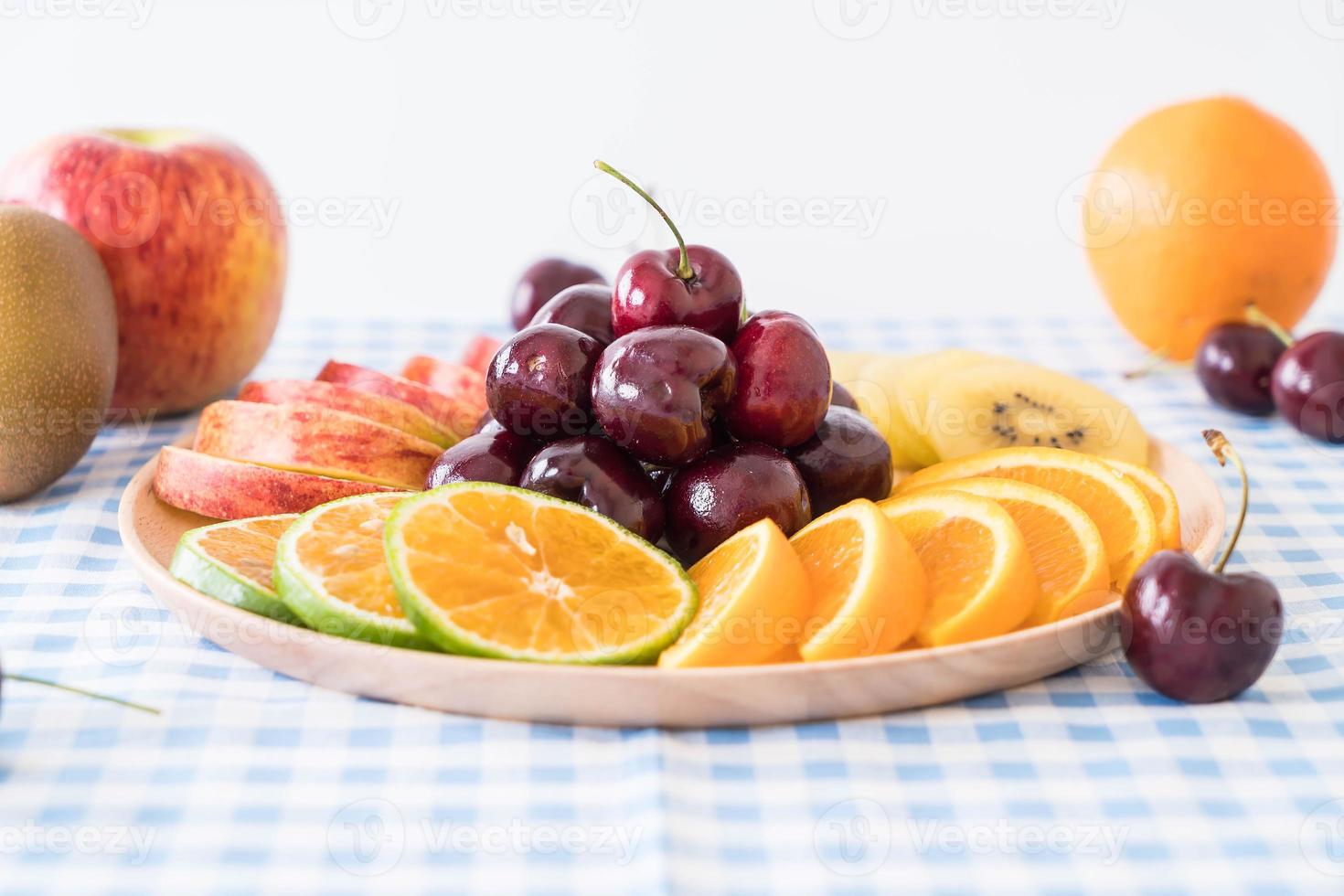 frutta mista a fette nel piatto di legno foto