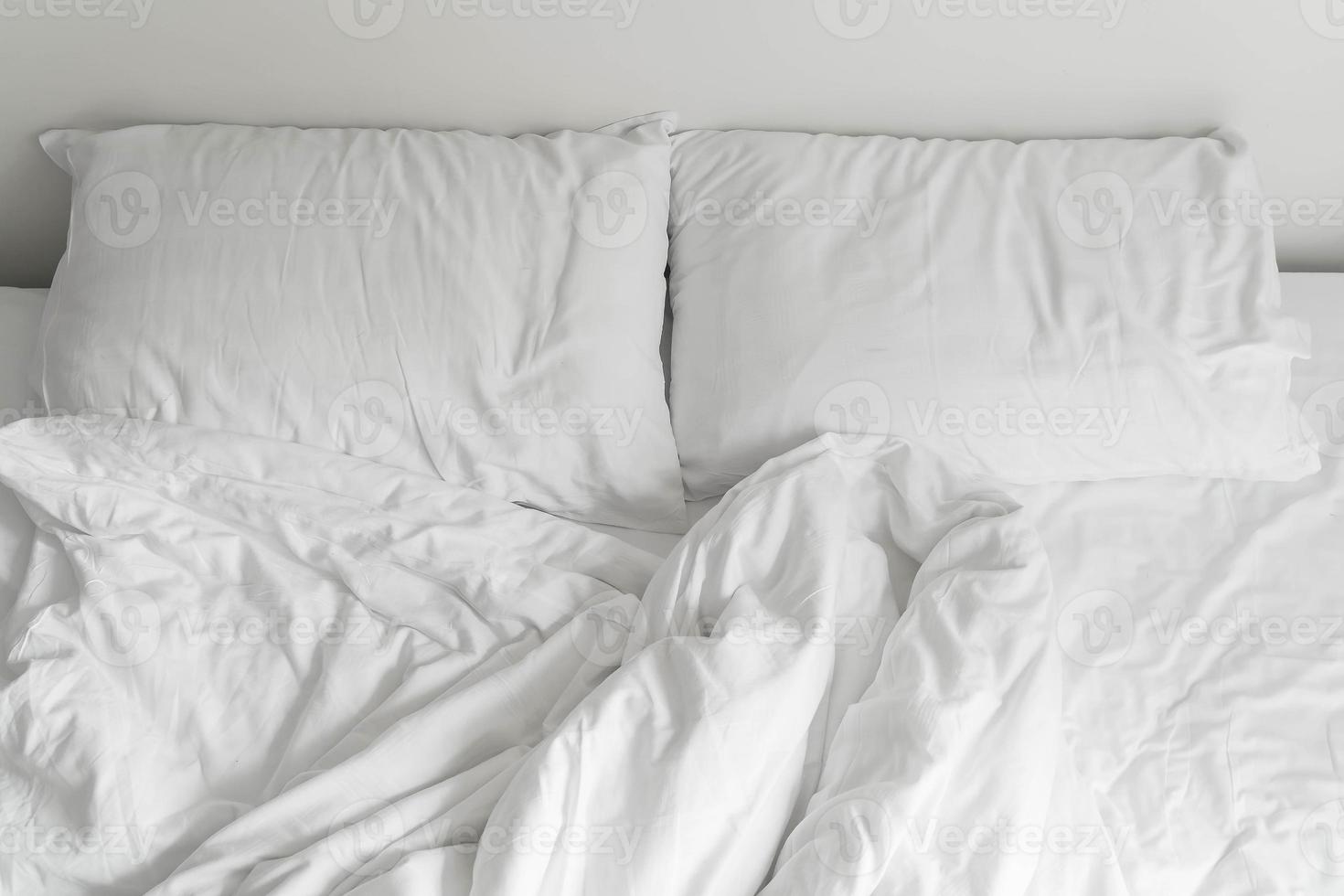 letto increspato con decorazione cuscino disordinato bianco nell'interno della camera da letto foto