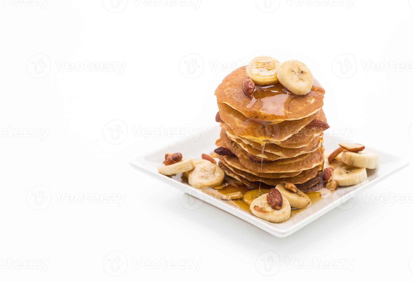 pancake alla banana alle mandorle con miele su sfondo bianco foto
