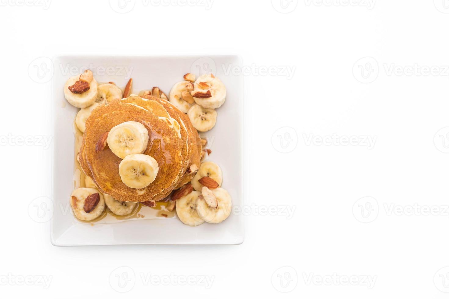 pancake alla banana alle mandorle con miele su sfondo bianco foto