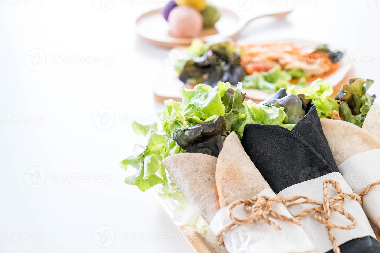 avvolgere il rotolo di insalata sul tavolo foto