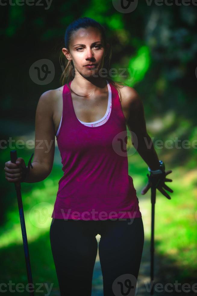 una bellissima ragazza pratica il nordic walking foto