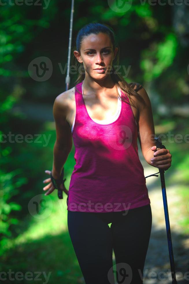 una giovane donna pratica il nordic walking foto