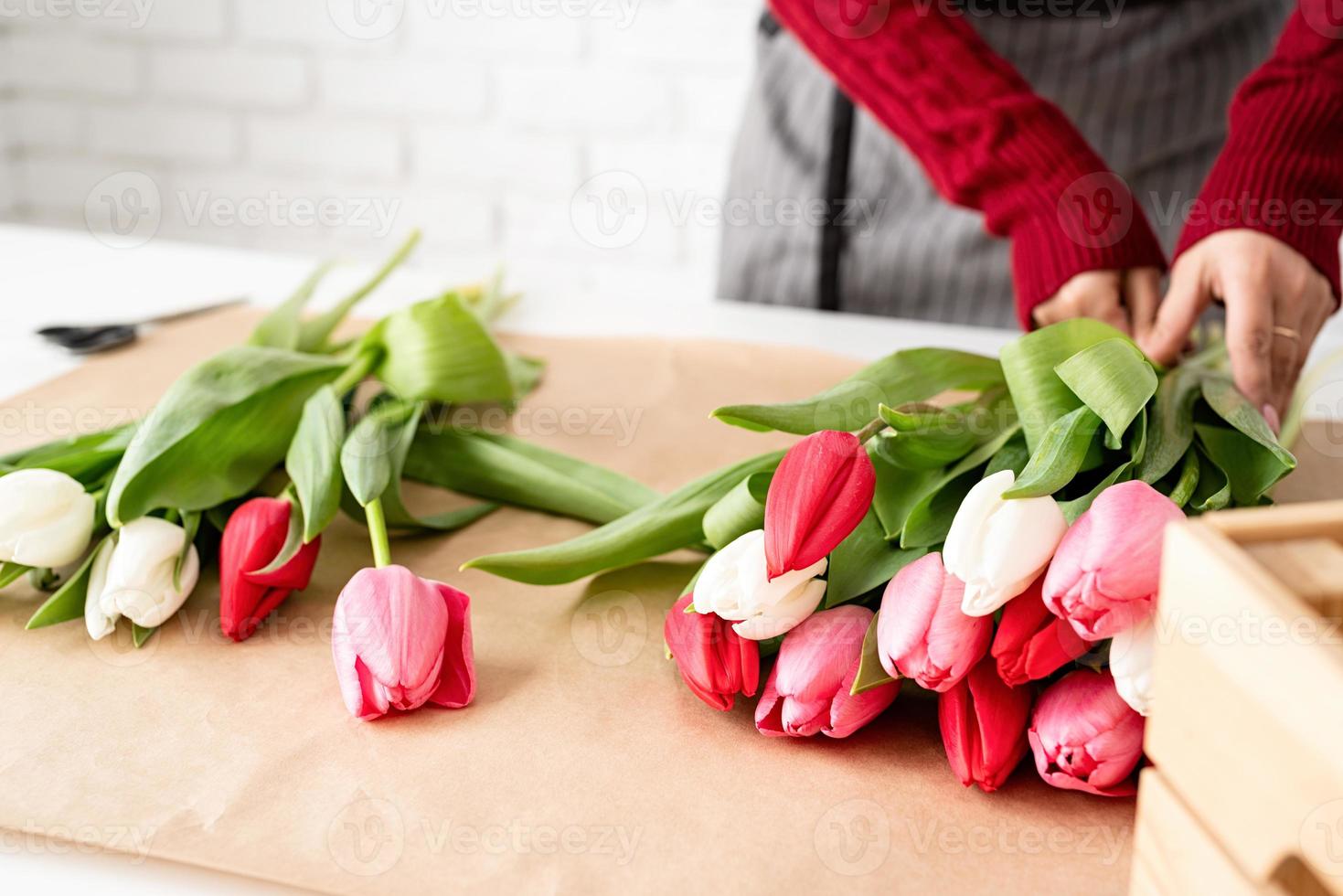 fiorista donna che fa un mazzo di tulipani freschi e colorati foto