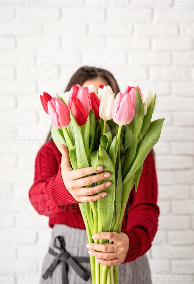 fiorista donna che fa un mazzo di tulipani freschi e colorati foto