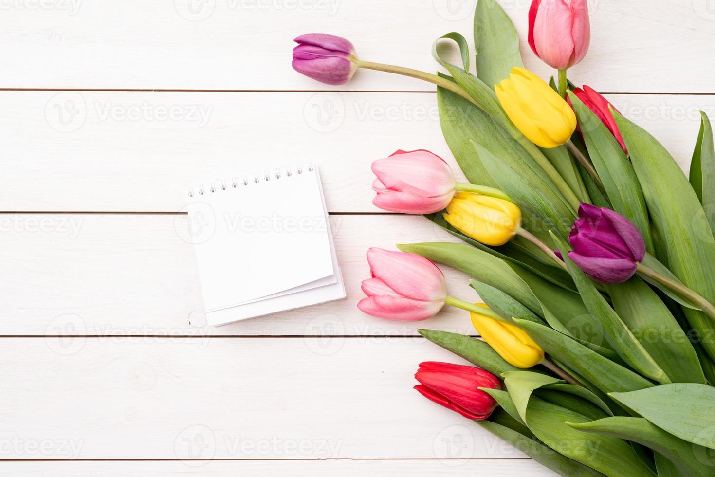 vista dall'alto del calendario vuoto con tulipani colorati su sfondo bianco foto