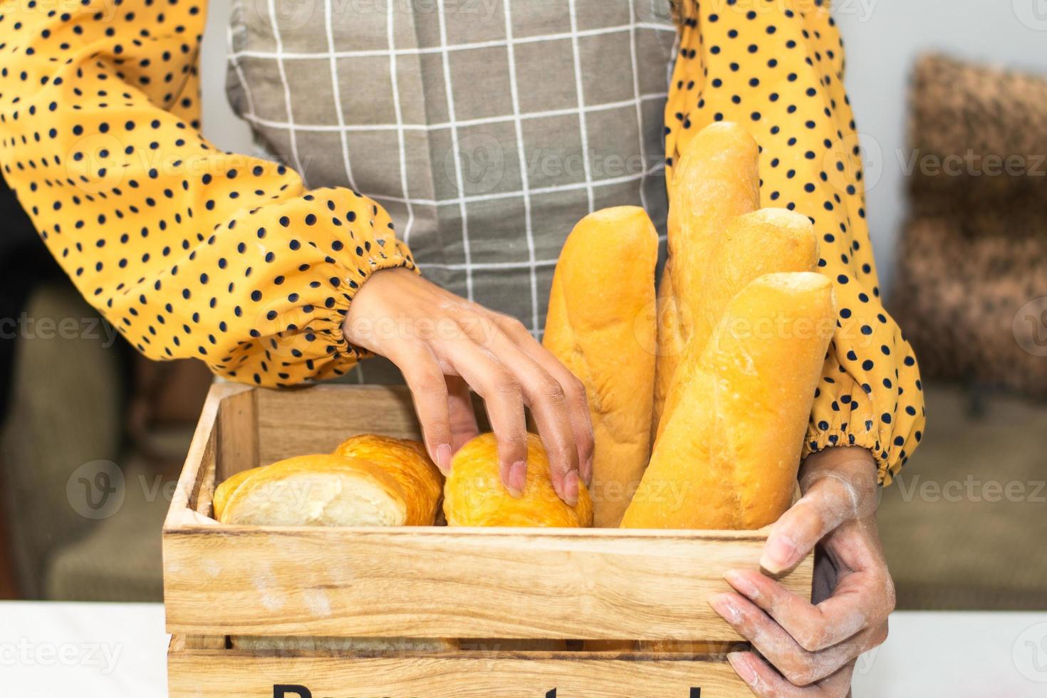 mano che tiene il secchio di pane fresco nel negozio di pane foto