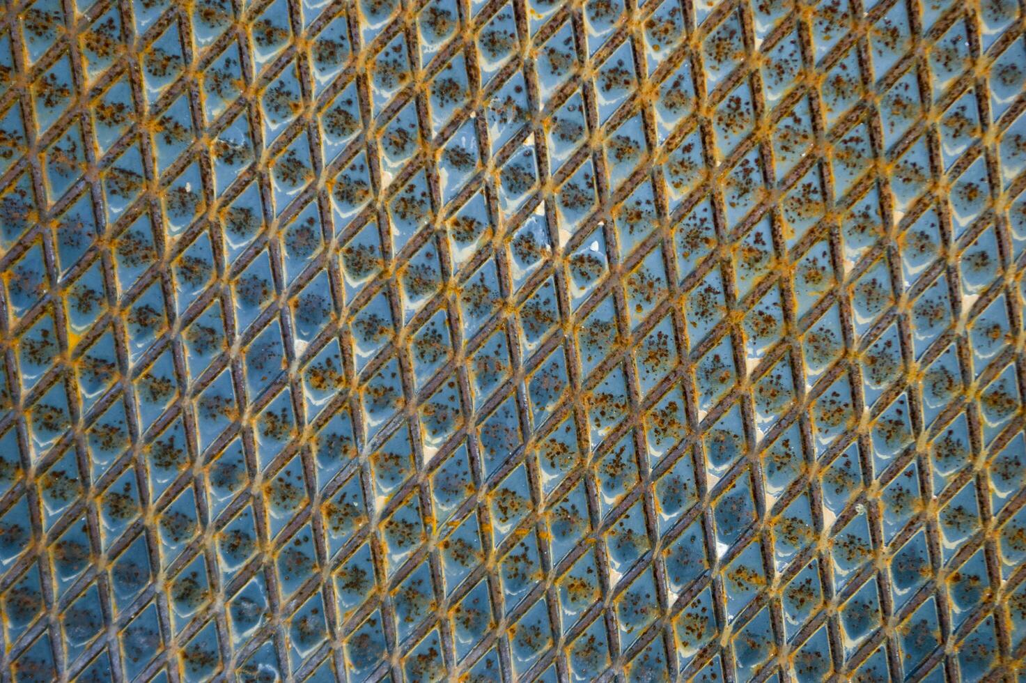 un' vicino su di un' metallo superficie con blu e giallo colori foto