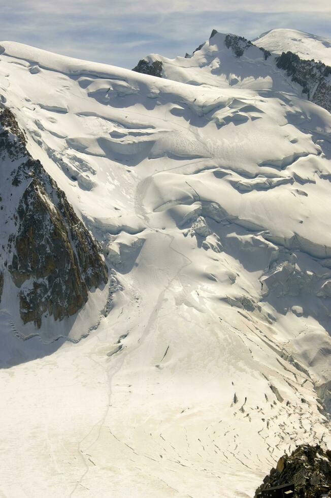 Due persone siamo escursioni a piedi su un' montagna con neve coperto montagne foto