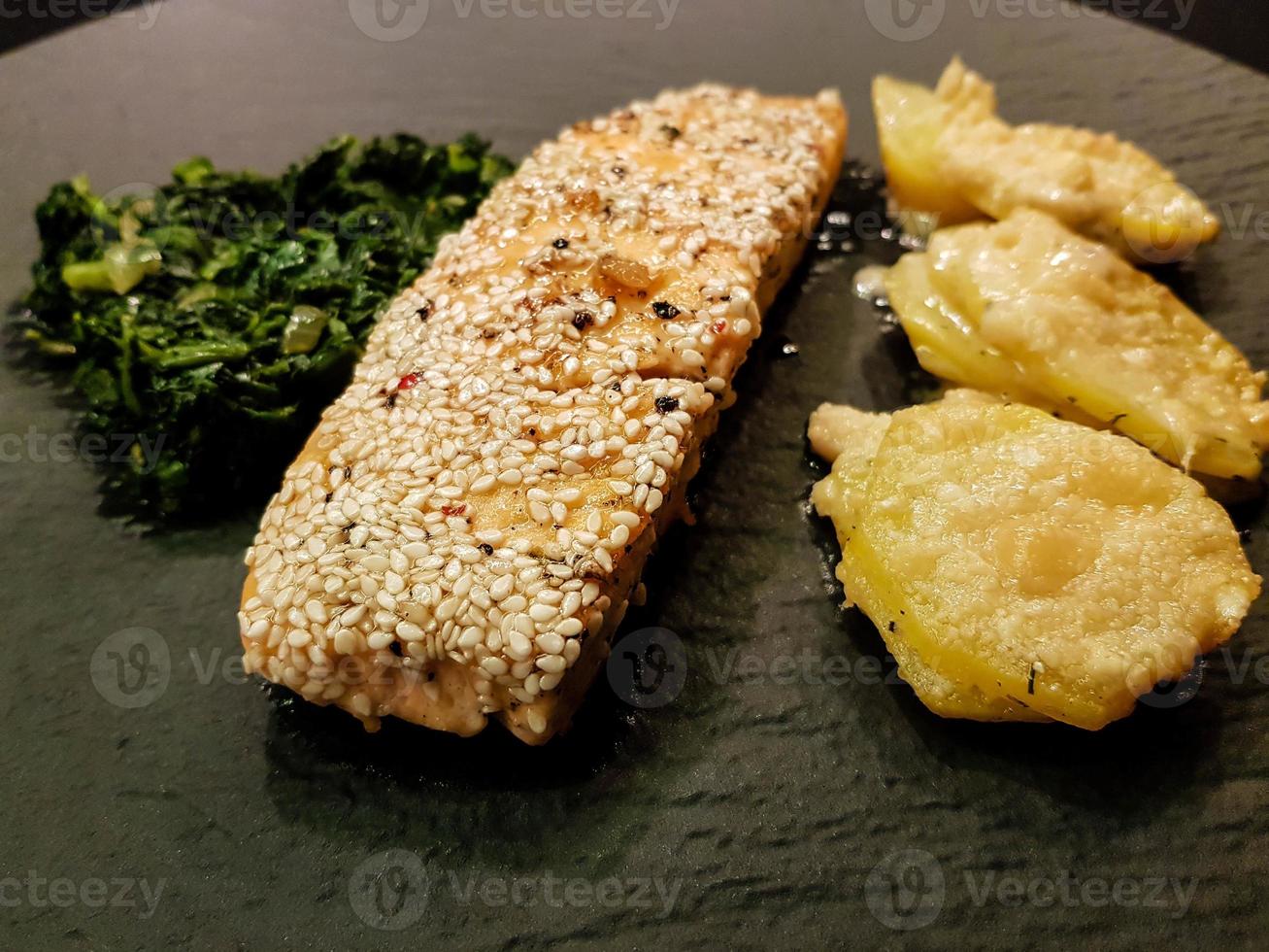 trancio di salmone con crema di spinaci e patate al forno foto