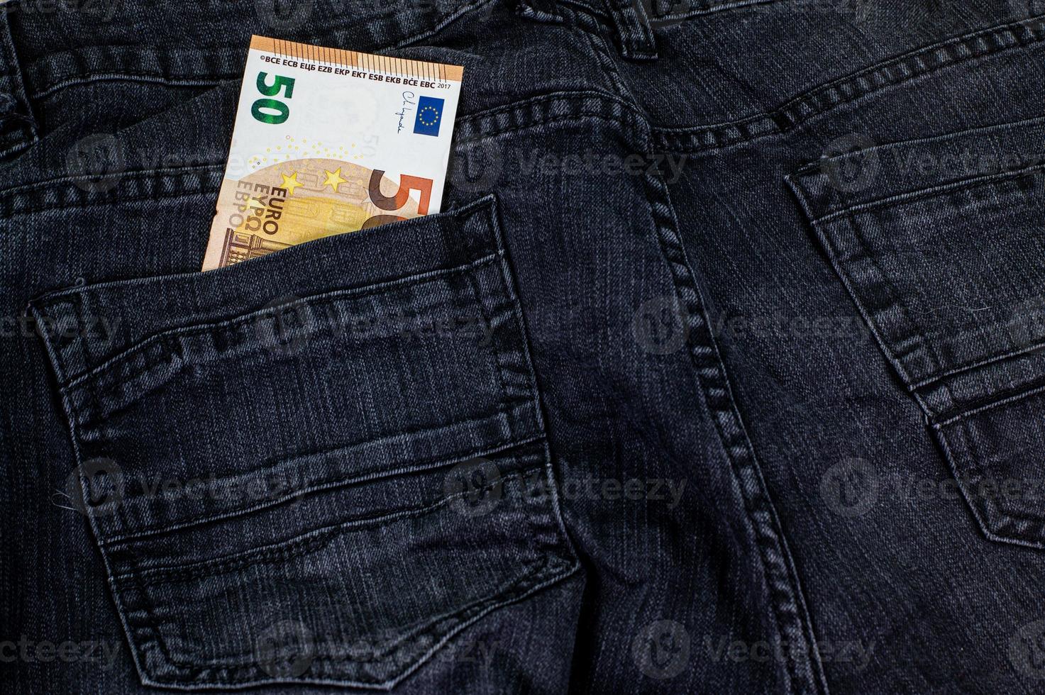 50 euro che escono dalla tasca dei jeans foto