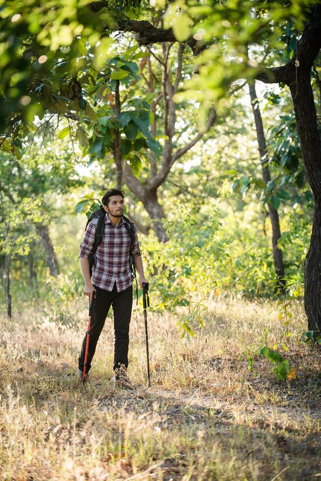 giovane uomo hipster che cammina sulla strada rurale durante le escursioni in vacanza. foto