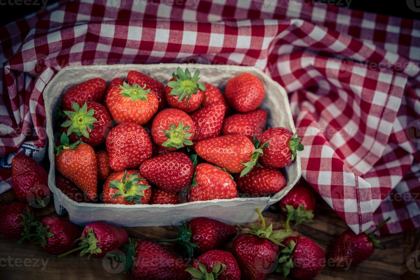 frutti di fragola in una scatola di carta foto