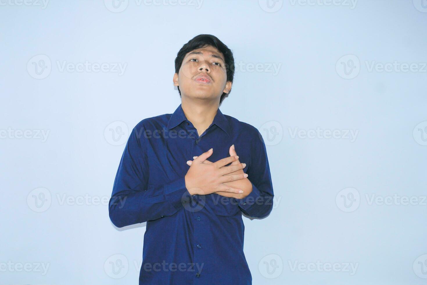 giovane asiatico uomo è rilassante a partire dal cuore attacco dolore fare inalare e espirando viso espressione e gesto indossare Marina Militare camicia foto