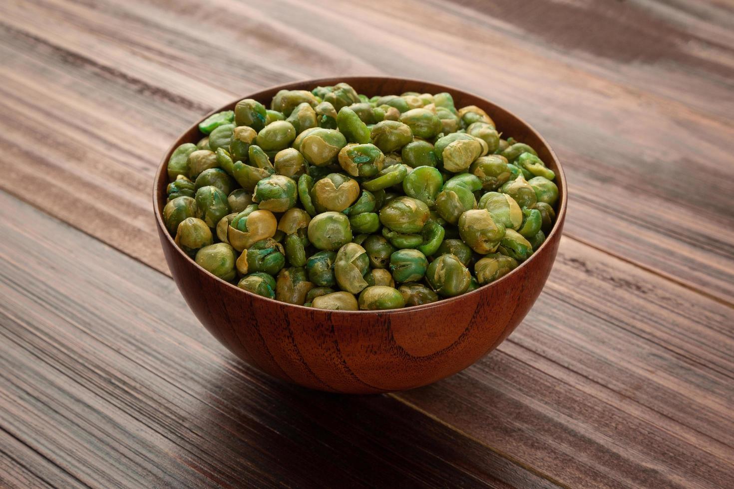 piselli salati in ciotola di legno sul tavolo, spuntino sano healthy foto