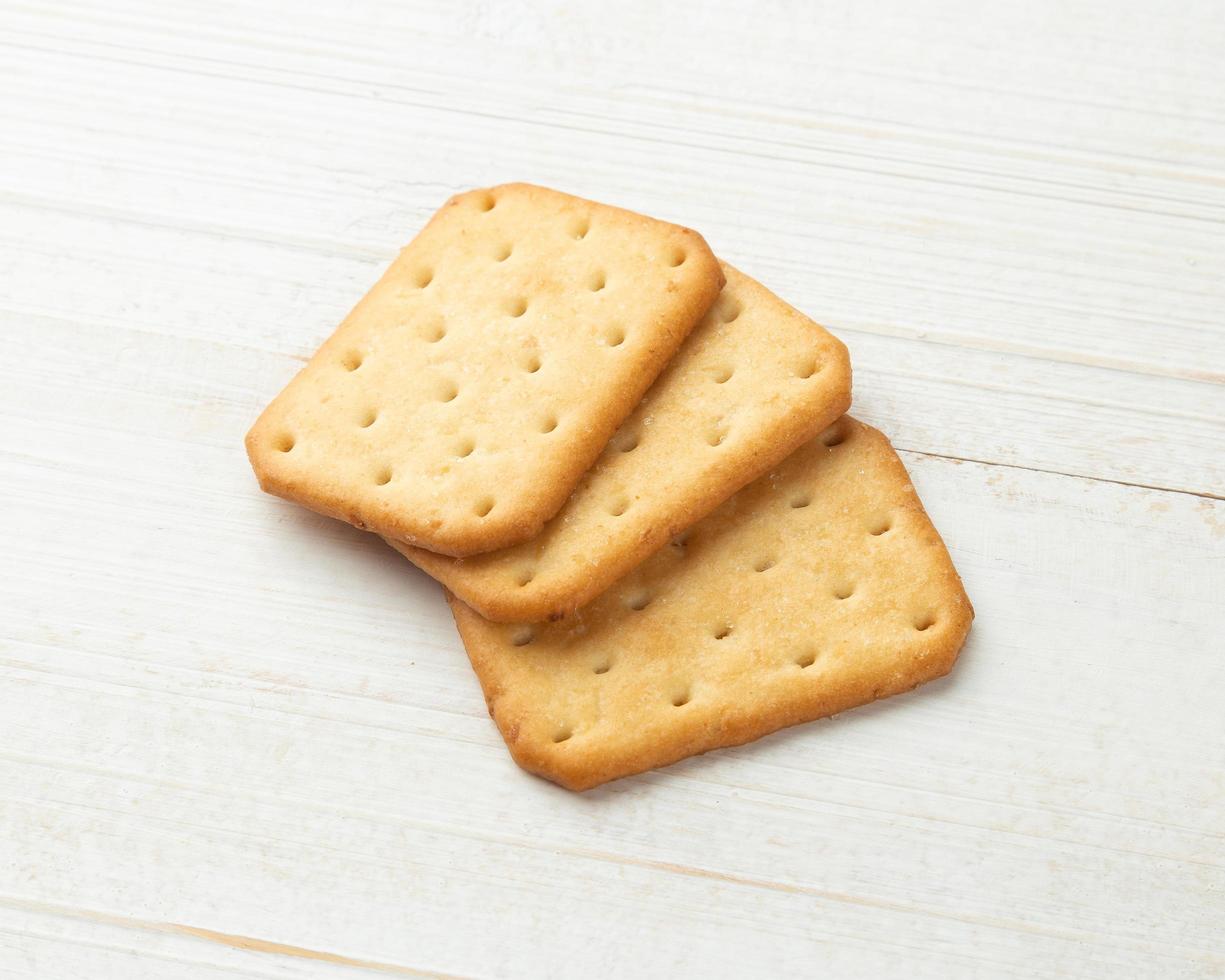 biscotti cracker su sfondo bianco tavolo in legno foto