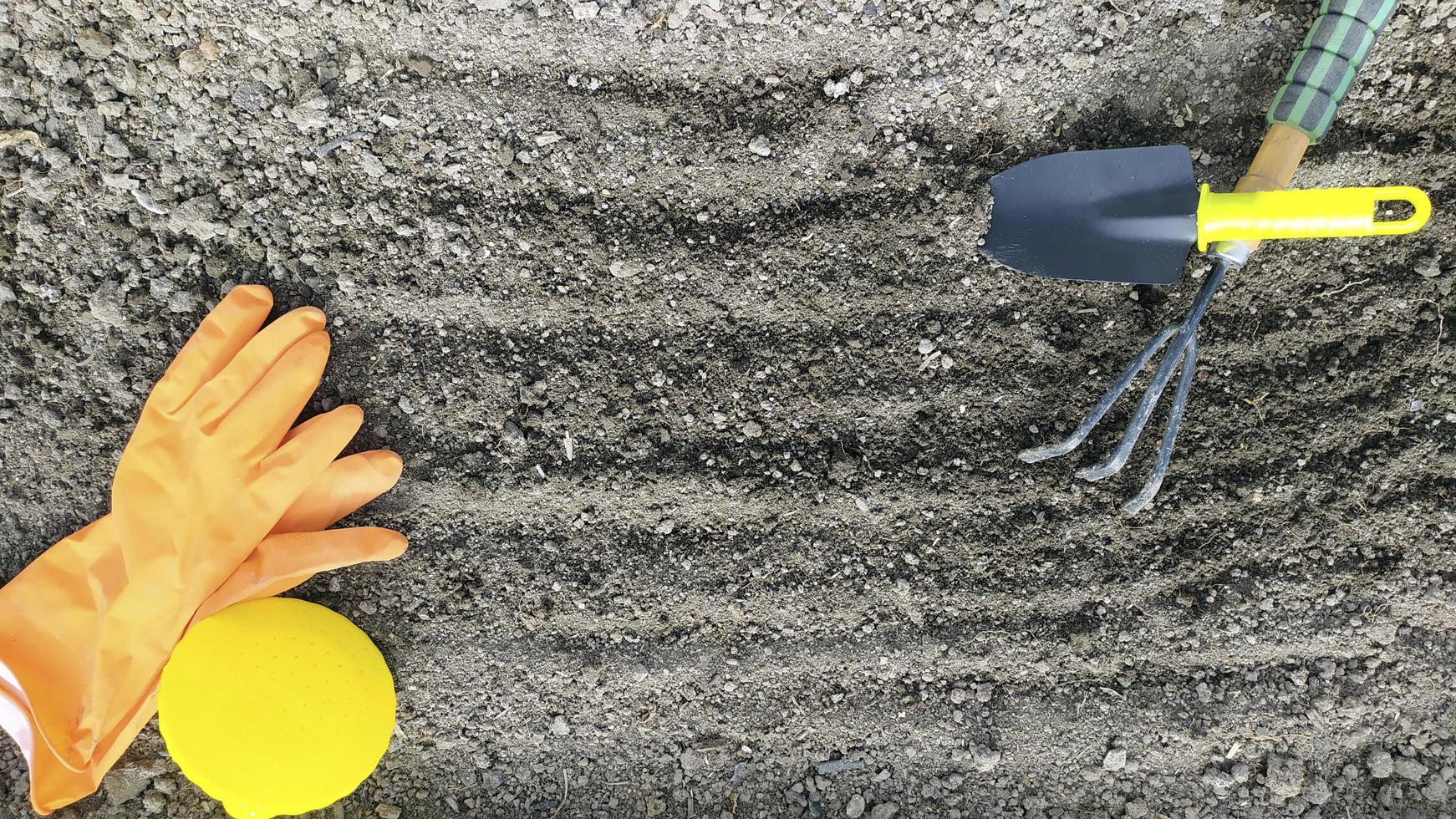 gli attrezzi da giardinaggio giacciono sul terreno scavato. preparare il terreno foto