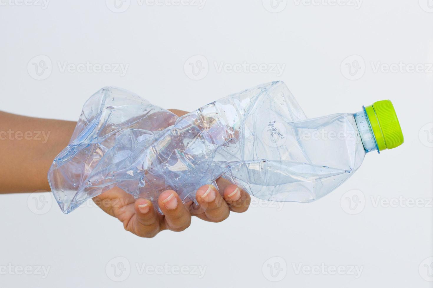 mano che tiene una bottiglia di plastica usata foto