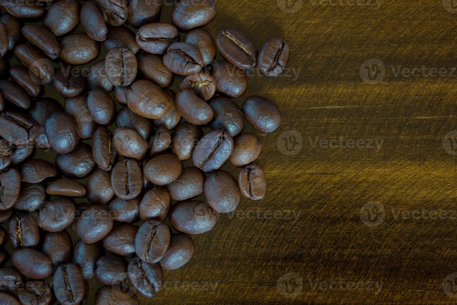 chicchi di caffè del primo piano estremo su fondo di legno, tono scuro. vista dall'alto foto