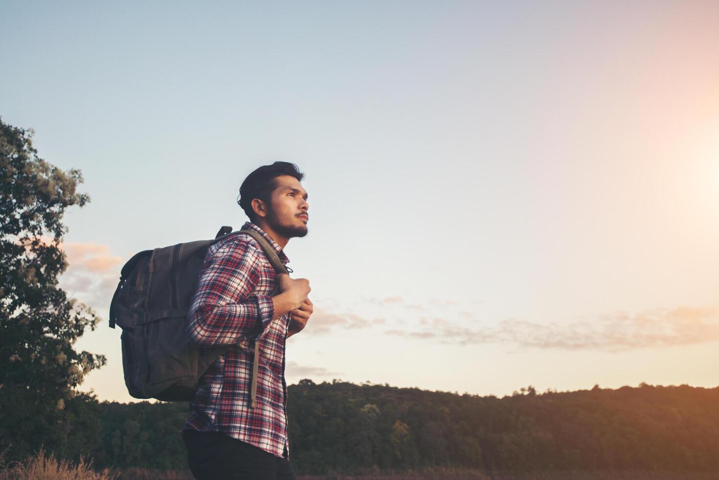 hipster escursionista uomo in piedi sulla roccia e godersi il tramonto sul lago. foto