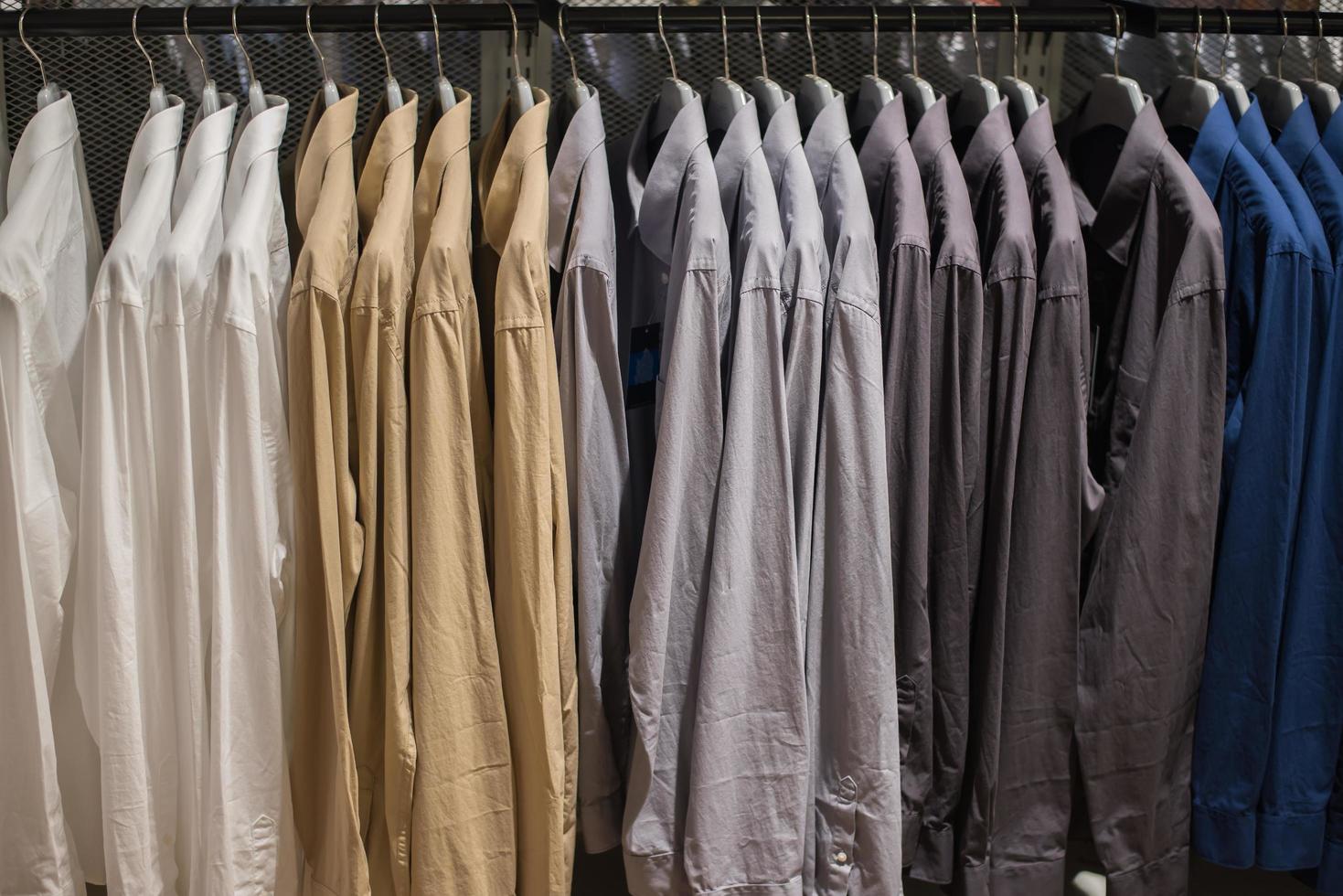 camicia appesa su rotaia al negozio di abbigliamento. foto