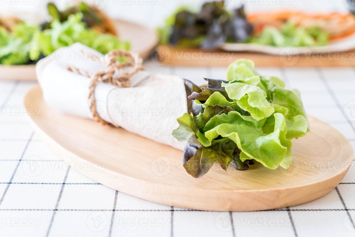 avvolgere il rotolo di insalata sul tavolo foto