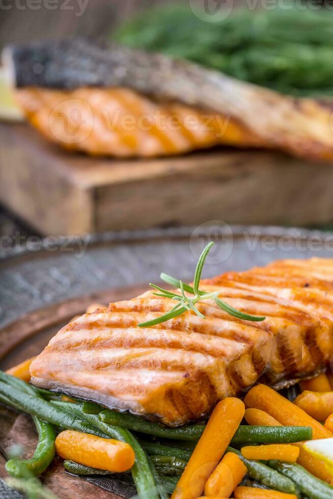 grigliato salmone bistecca con verdura e erbe aromatiche. foto