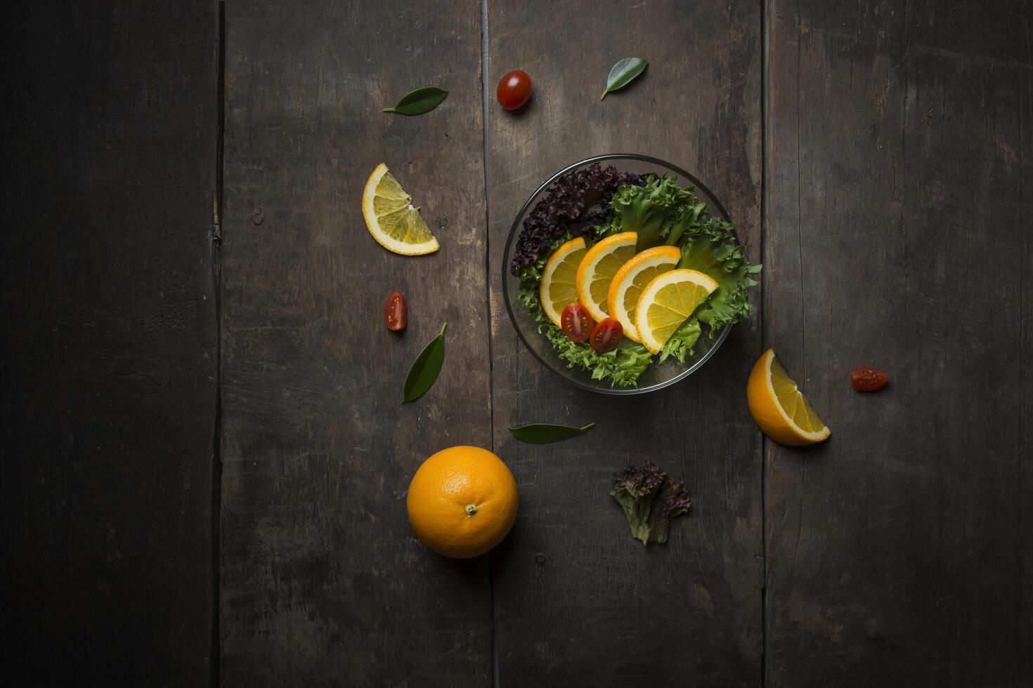 insalata fresca con fetta di arancia su fondo di legno foto