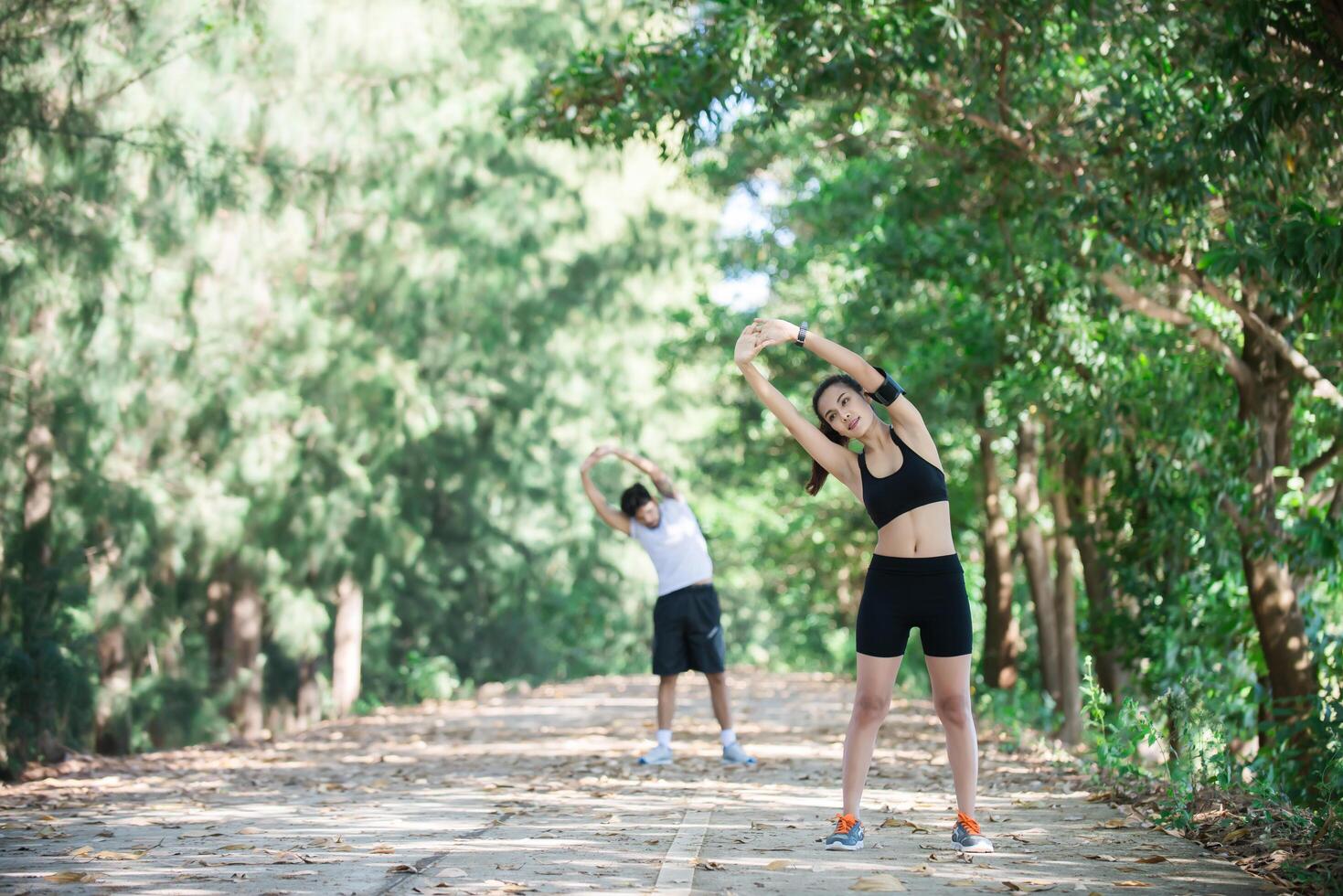 uomo e donna che si allungano insieme al parco. foto