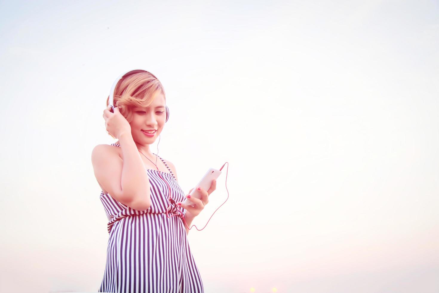 bella donna sexy che ascolta musica da smartphone in fiore. foto