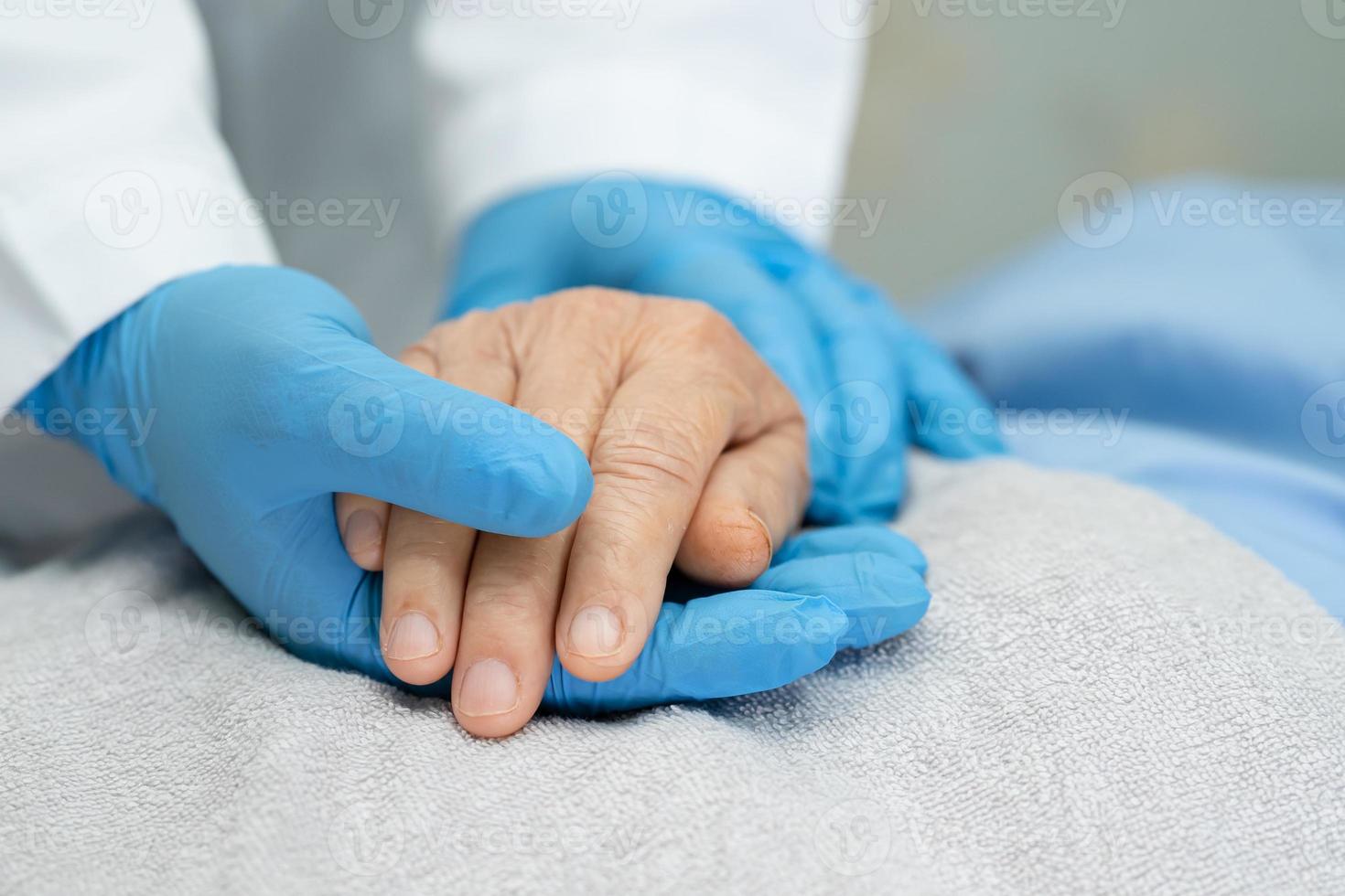medico che si tiene per mano donna anziana asiatica paziente infetto con amore foto