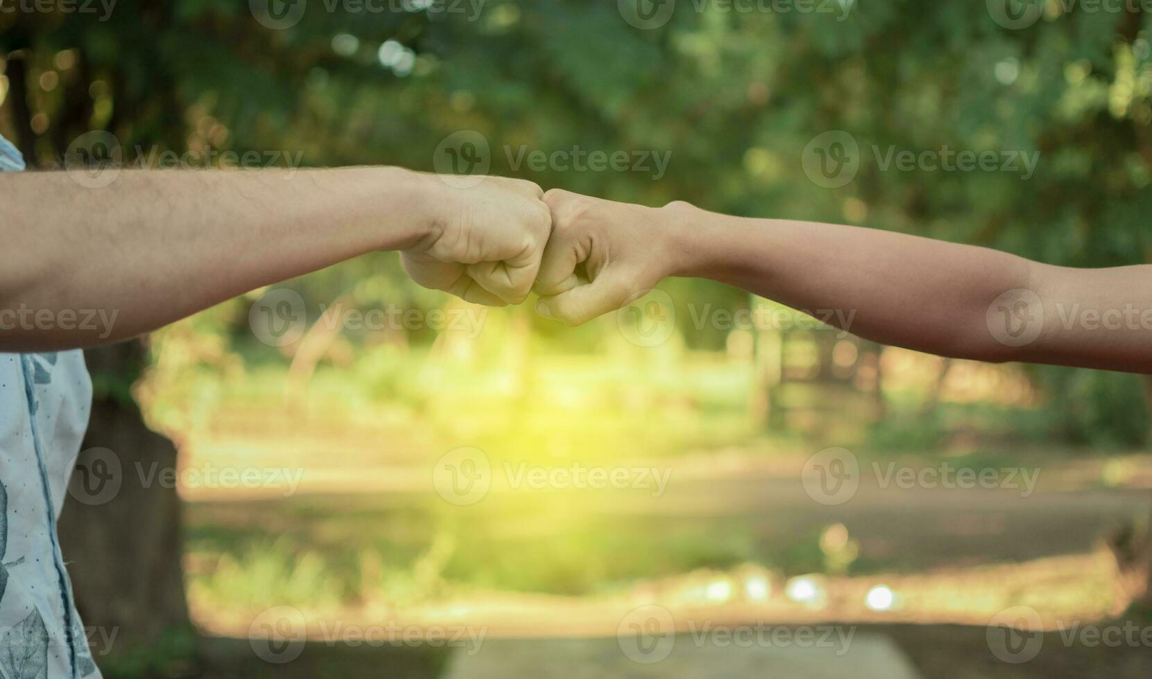 Due giovane uomini scontrandosi loro pugni, Immagine di Due giovane uomini urtando loro pugni nel un' amichevole modo, vicino su di Due pugni urtando nel un' amichevole modo foto