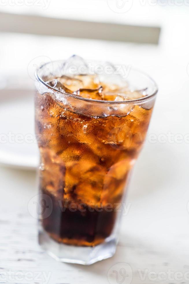 bicchiere di cola ghiacciata sul tavolo foto