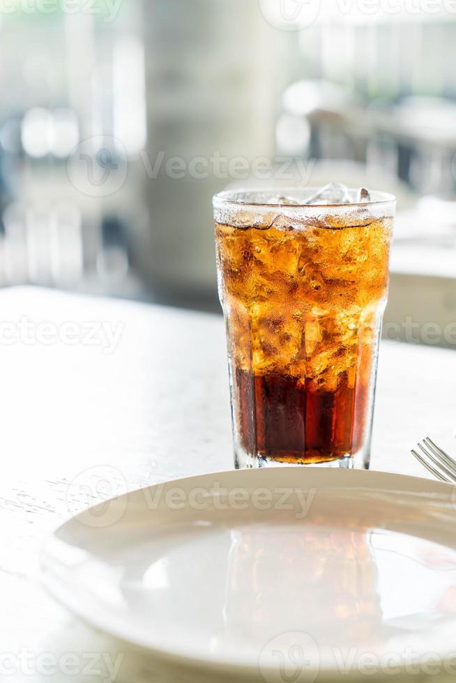 bicchiere di cola ghiacciata sul tavolo foto