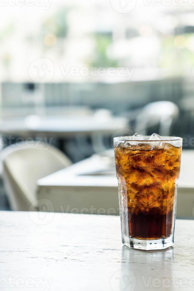 bicchiere di cola ghiacciata sul tavolo foto