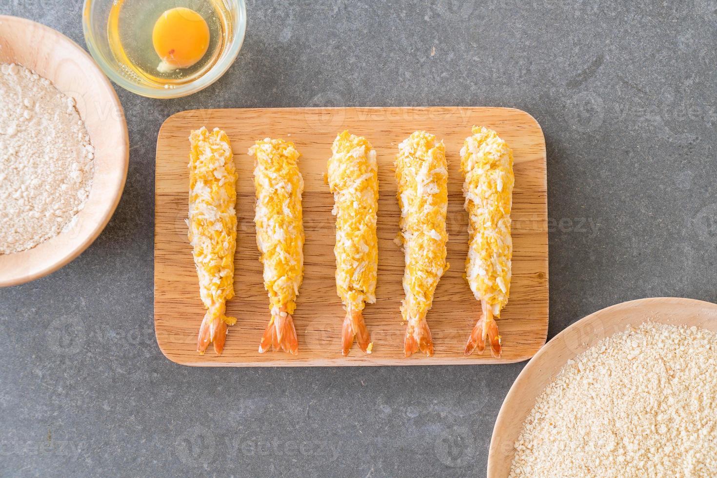 gamberi in pastella su tavola di legno con ingredienti foto