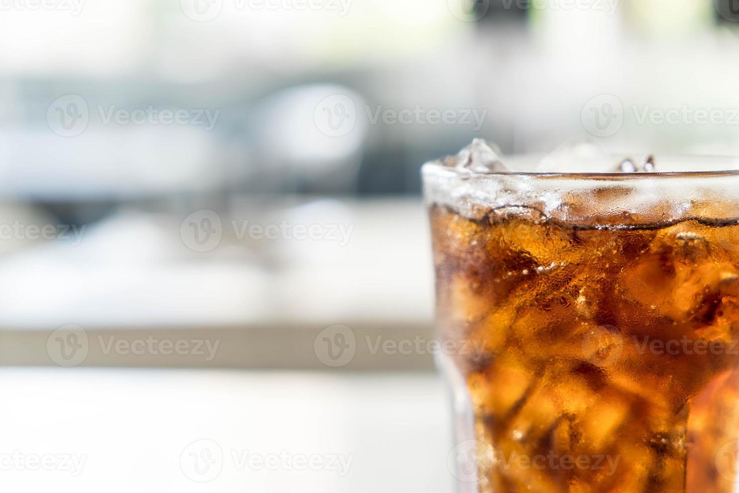 bicchiere di cola ghiacciata sul tavolo foto