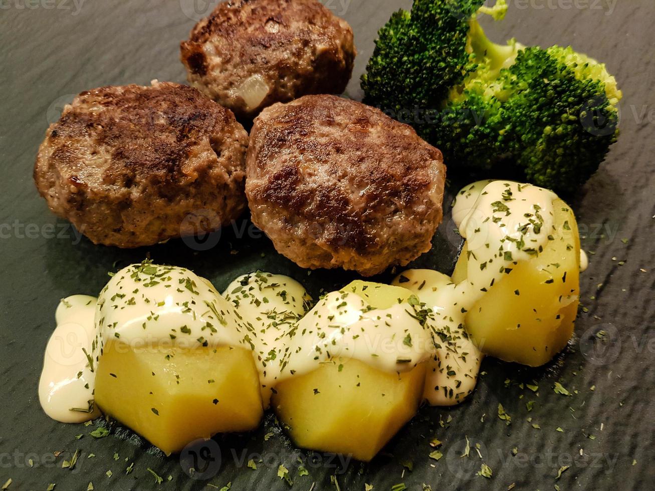 polpette fritte con broccoli lessati e patate al prezzemolo foto