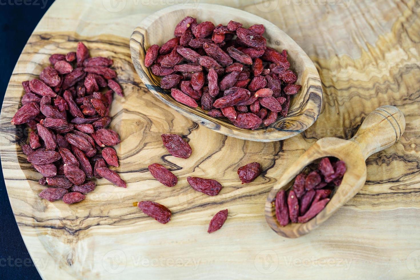 bacche di goji essiccate su legno d'ulivo foto