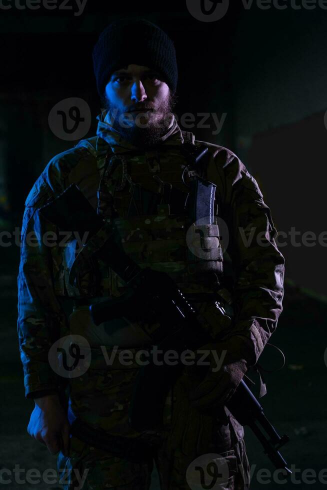 esercito soldato nel combattere uniformi con un assalto fucile e combattere casco notte missione buio sfondo. blu e viola gel leggero effetto. foto