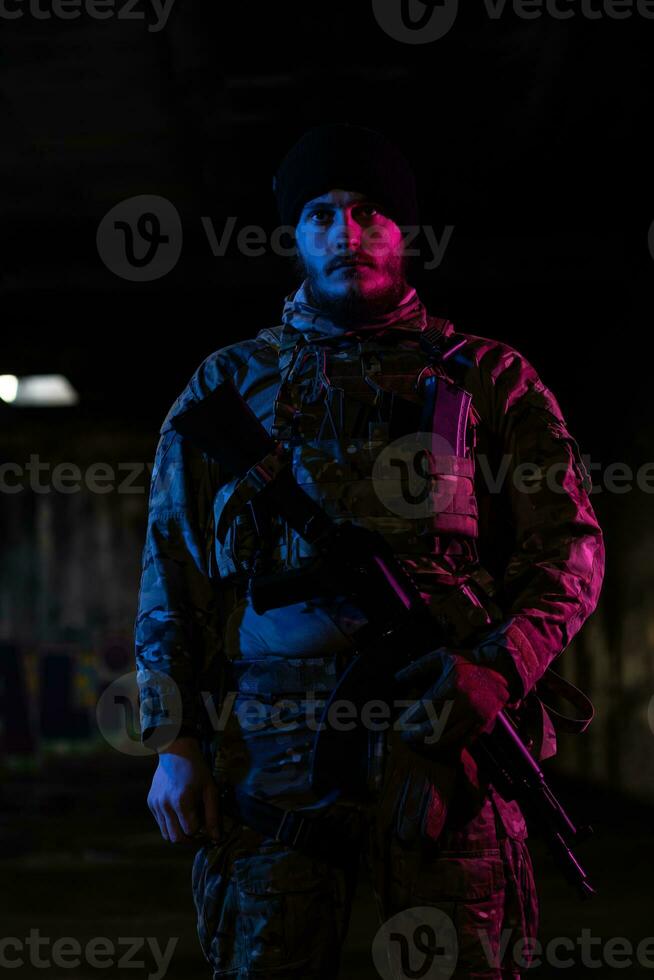 esercito soldato nel combattere uniformi con un assalto fucile e combattere casco notte missione buio sfondo. blu e viola gel leggero effetto. foto