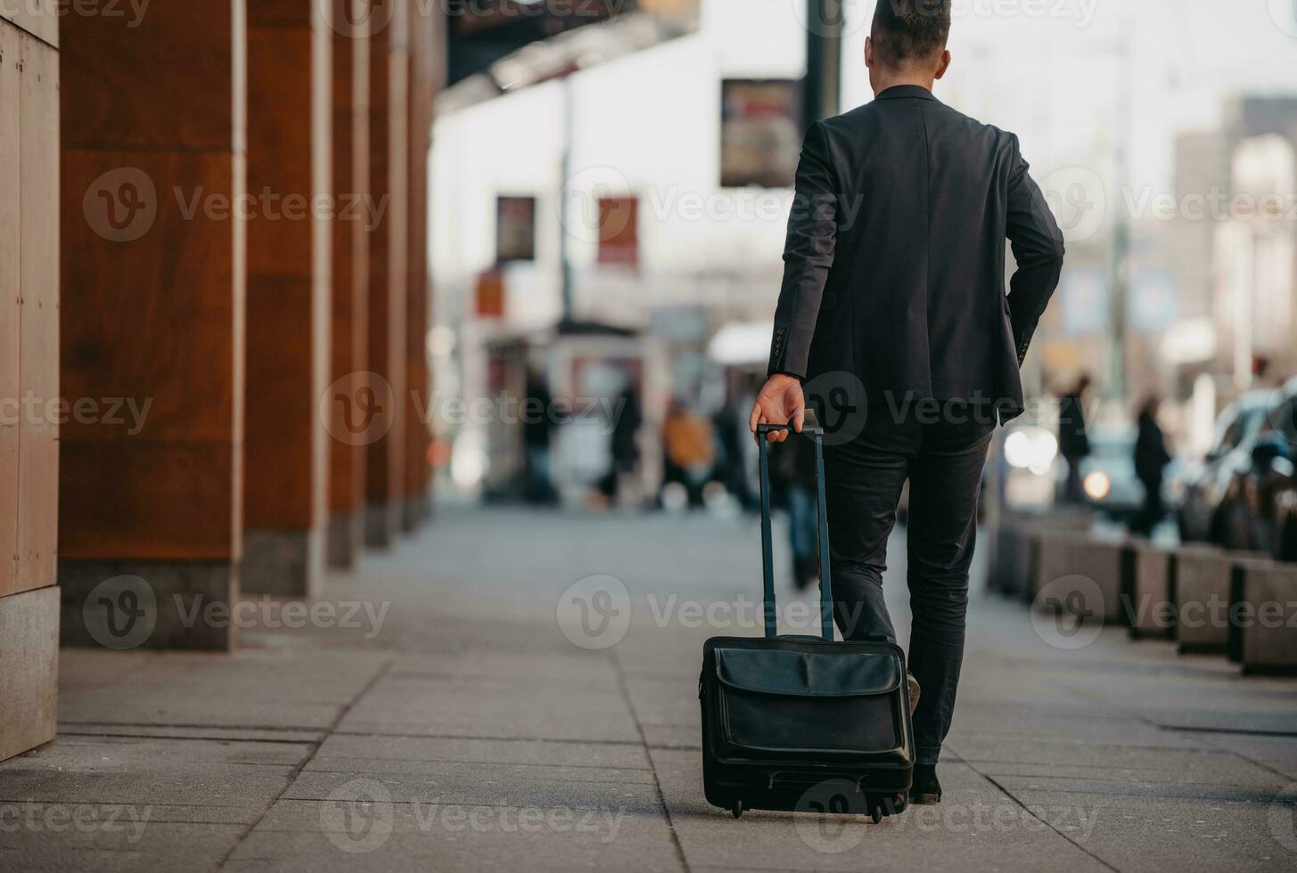 andando per aeroporto terminale. fiducioso uomo d'affari viaggiatore a piedi su città strade e traino il suo valigia potabile caffè e A proposito di su smartphone foto