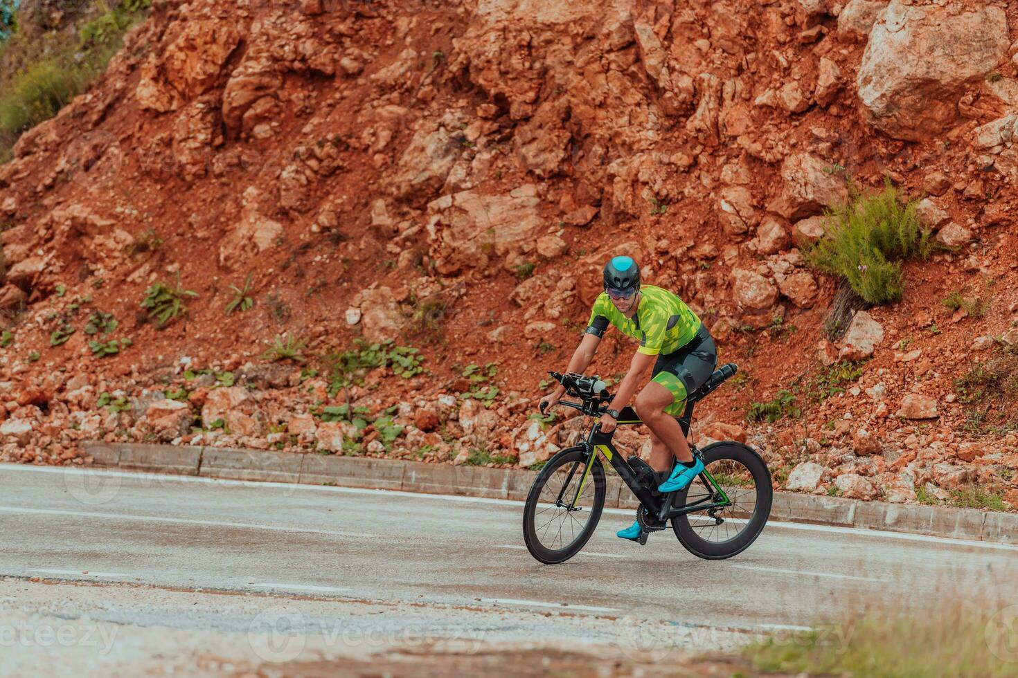 pieno lunghezza ritratto di un attivo triatleta nel abbigliamento sportivo e con un' protettivo casco equitazione un' bicicletta. selettivo messa a fuoco foto