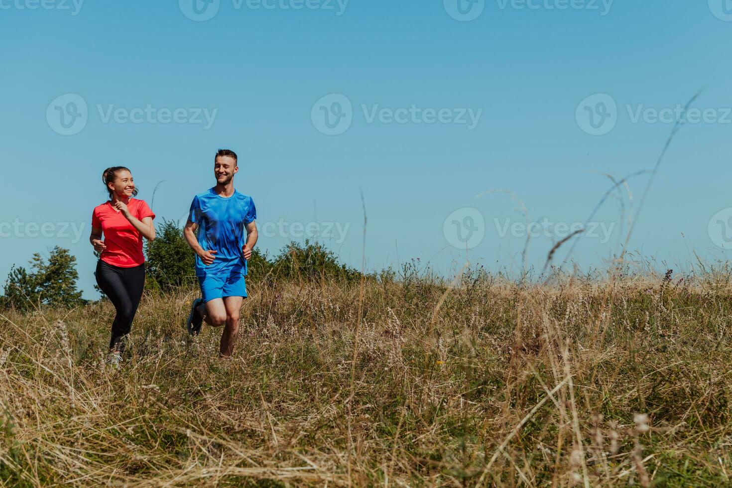 coppia godendo nel un' salutare stile di vita mentre jogging su un' nazione strada attraverso il bellissimo soleggiato foresta, esercizio e fitness concetto foto