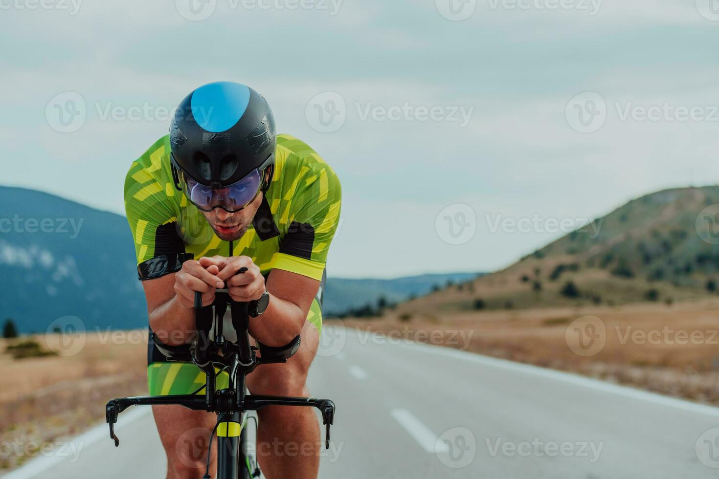 vicino su foto di un attivo triatleta nel abbigliamento sportivo e con un' protettivo casco equitazione un' bicicletta. selettivo messa a fuoco