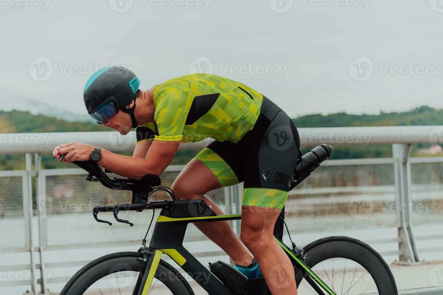 pieno lunghezza ritratto di un attivo triatleta nel abbigliamento sportivo e con un' protettivo casco equitazione un' bicicletta. selettivo messa a fuoco foto