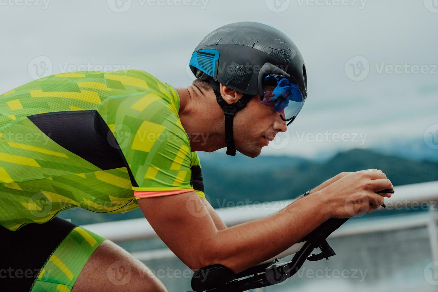vicino su foto di un attivo triatleta nel abbigliamento sportivo e con un' protettivo casco equitazione un' bicicletta. selettivo messa a fuoco