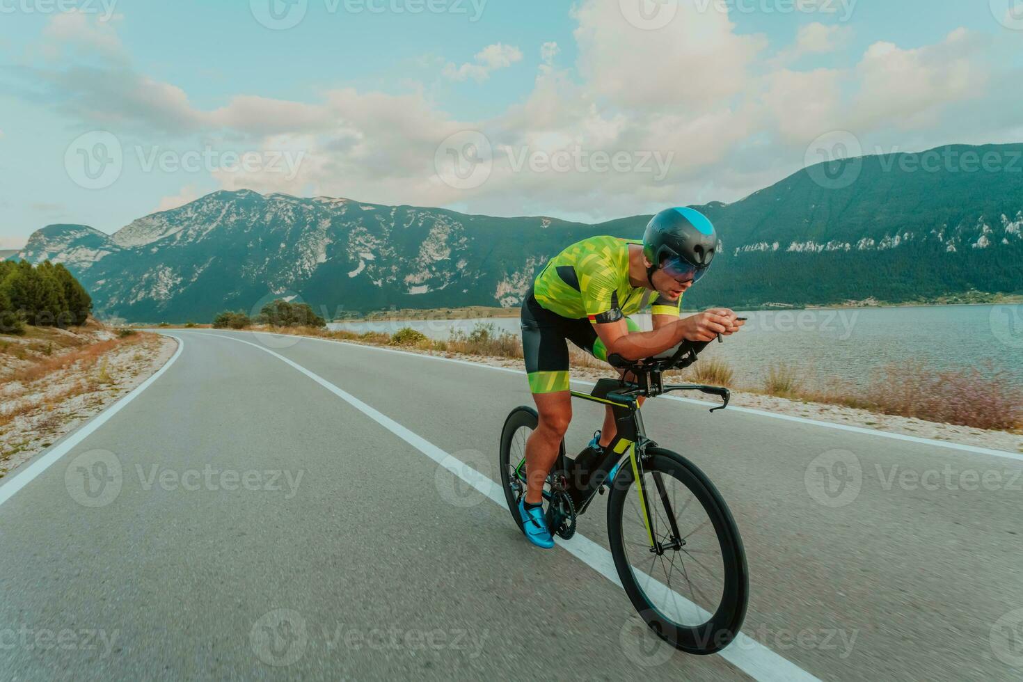 pieno lunghezza ritratto di un attivo triatleta nel abbigliamento sportivo e con un' protettivo casco equitazione un' bicicletta. selettivo messa a fuoco foto