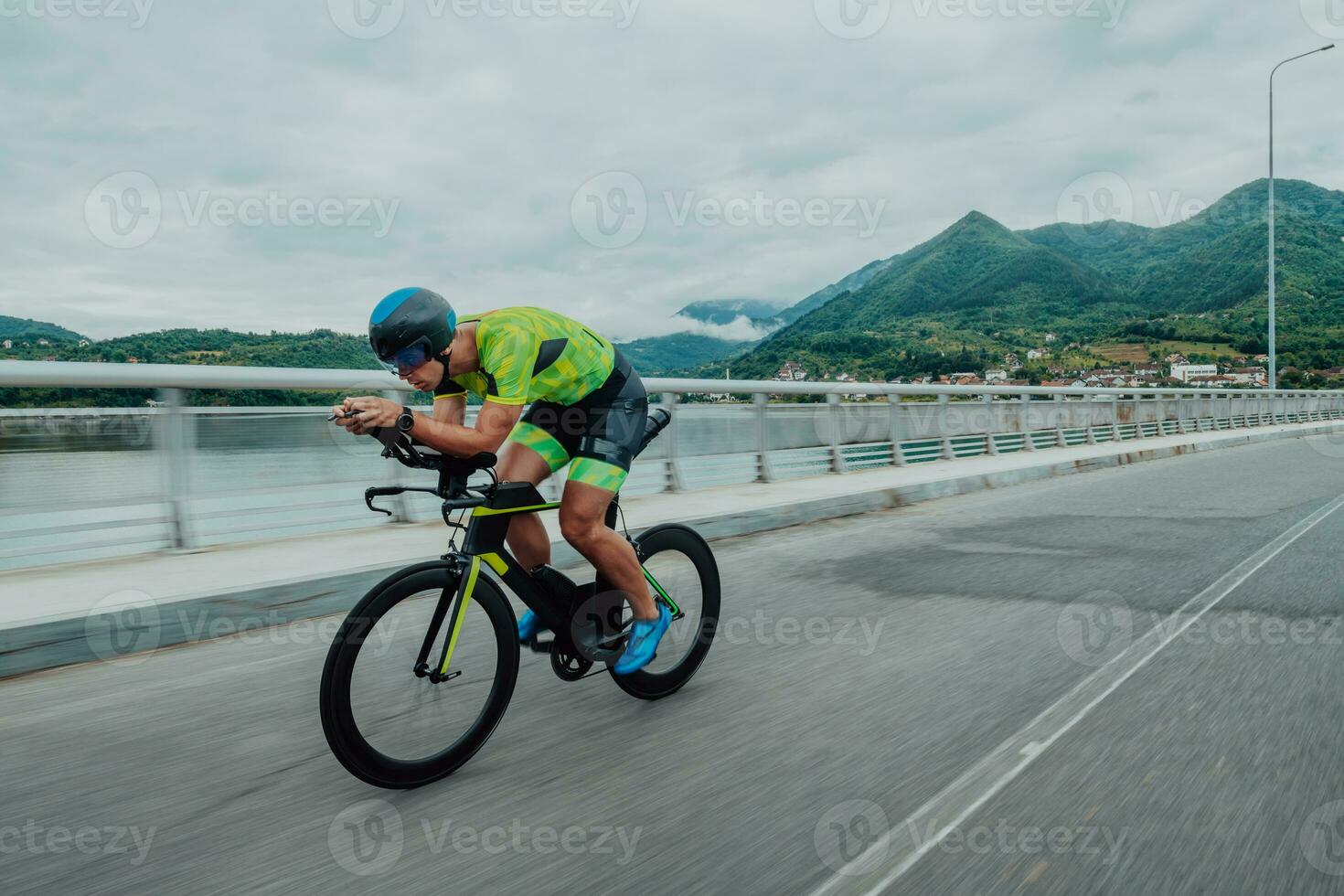 pieno lunghezza ritratto di un attivo triatleta nel abbigliamento sportivo e con un' protettivo casco equitazione un' bicicletta. selettivo messa a fuoco foto